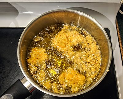 Picture of pakoras frying in hot oil.