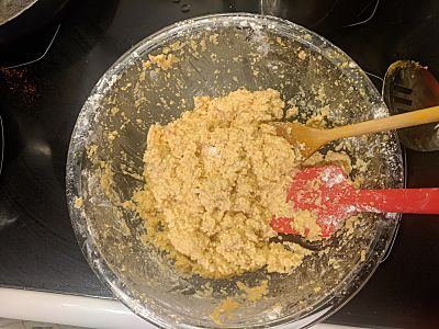 Image of pakoras with chickpeas dough in a glass bowl with a wooden spoon and red spatulas.